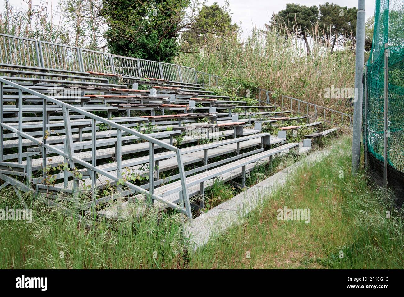 abandoned-bleachers-in-front-of-a-baseball-court-in-tuscany-italy-2FK0G1G.jpg